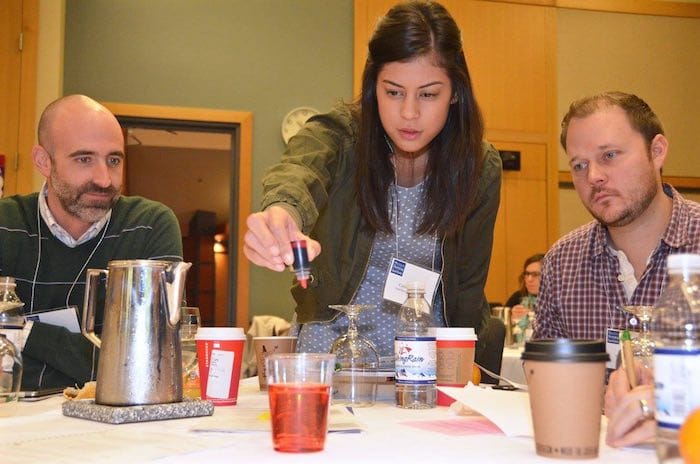 attendees engaged in experimenting at their table (mixing fluids)