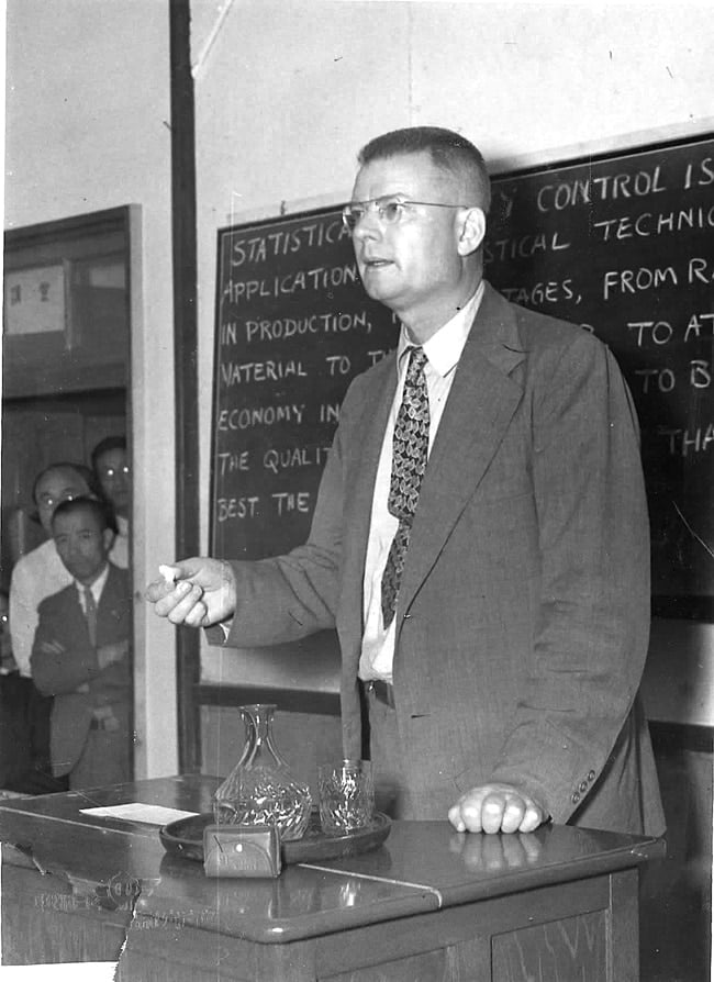 photo of Dr. Deming in front of a blackboard