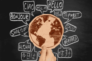 Black chalkboard with "hello" in 12 different languages around a cutout image of a world map.